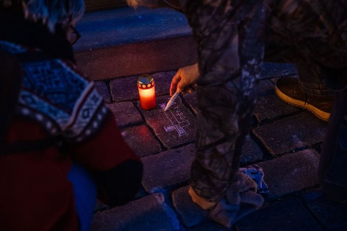 Lidé na Staroměstském náměstí v Praze spontánně uctívají oběti pandemie u křížů, které zde křídou nakreslila iniciativa Milion chvilek pro demokracii. 24 - 25. 3. 2021