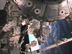 Astronauti Mike Fossum (vlevo) a Piers Sellers vyměňují nefunkční součástku na staničním mobilním transportéru.