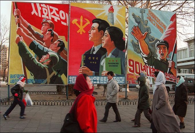 Pedestrians walk past giant propaganda boards 27 January1995 in central Pyongyang.