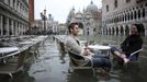 Tourists sit in St. Mark Square during a period of seasonal high water in Venice October 27, 2012. The water level in the canal city rose to 127 cm (50 inches) above the normal level, according to the monitoring institute. REUTERS/Manuel Silvestri (ITALY - Tags: ENVIRONMENT SOCIETY TRAVEL TPX IMAGES OF THE DAY) Published: Říj. 27, 2012, 12:02 odp.