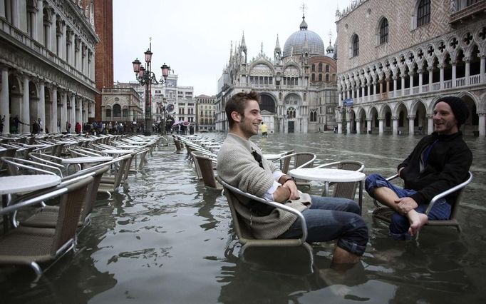 Tourists sit in St. Mark Square during a period of seasonal high water in Venice October 27, 2012. The water level in the canal city rose to 127 cm (50 inches) above the normal level, according to the monitoring institute. REUTERS/Manuel Silvestri (ITALY - Tags: ENVIRONMENT SOCIETY TRAVEL TPX IMAGES OF THE DAY) Published: Říj. 27, 2012, 12:02 odp.