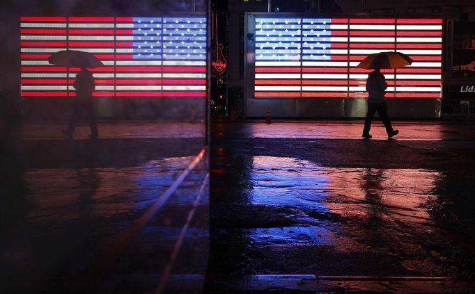 Světlo z neonové tabulí na Time Square vytvářelo na mokrém chodníků působivé odrazy.