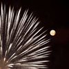Fireworks explode in front of the supermoon outside the town of Mosta