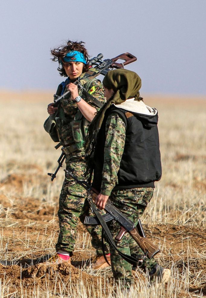 Female fighters of the Kurdish People's Protection Units (YPG) carry their weapons as they walk in the western countryside of Ras al-Ain January 25, 2015