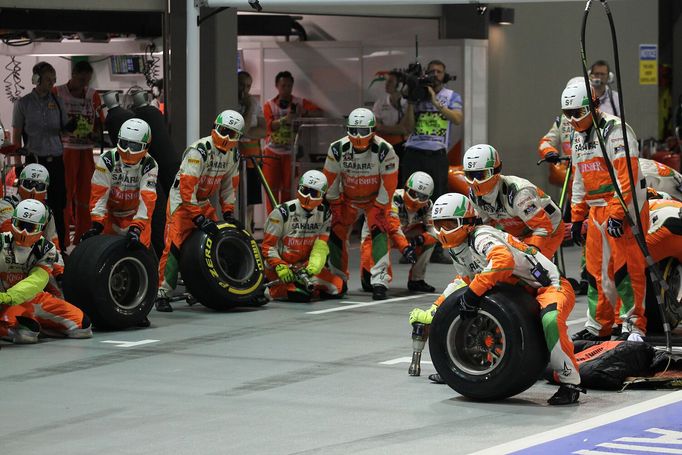 Tým Force India v bojovém postavení, pilot se blíží do boxů.