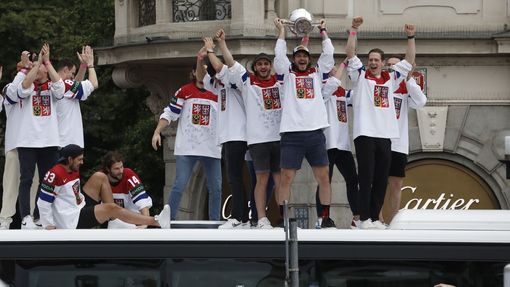 Čeští hokejisté zdraví s trofejí pro mistry světa fanoušky na Staroměstském náměstí ze střechy autobusu