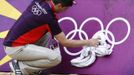 Simon Drew wipes down hoarding surrounding a practice beach volley ball court ahead of teams arriving for the London 2012 Olympic Games in London July 16, 2012. The London 2012 Olympic Games start in 11 days time. REUTERS/Luke MacGregor (BRITAIN - Tags: SPORT VOLLEYBALL OLYMPICS) Published: Čec. 16, 2012, 4:12 odp.