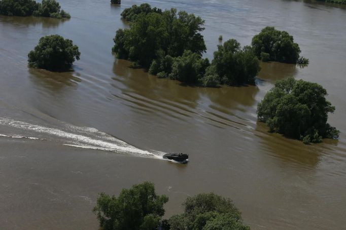 A boat of the German armed forces Bundeswehr rides in the flooded pastures after floods near Magdeburg in the federal state of Saxony Anhalt, June 10, 2013. Tens of thousands of Germans, Hungarians and Czechs were evacuated from their homes on Wednesday as soldiers raced to pile up sandbags to hold back rising waters in the region's worst floods in a decade. REUTERS/Thomas Peter (GERMANY - Tags: DISASTER ENVIRONMENT)