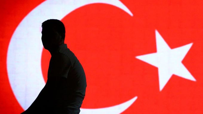 Silueta muže před tureckou vlajkou na letišti v Istanbulu