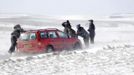 People try to move a car stuck in snow on the South Downs near Brighton in southern England March 12, 2013. Drivers were left stranded on Tuesday following a second day of heavy snowfall in southern England. REUTERS/Luke MacGregor (BRITAIN - Tags: ENVIRONMENT SOCIETY) Published: Bře. 12, 2013, 4:56 odp.