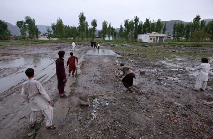 RNPS IMAGES OF THE YEAR 2012 - Children play cricket in the rain on the demolished site of the compound of Osama bin Laden, in Abbottabad April 20, 2012. Osama bin Laden was killed on May 2, 2011, by a United States special operations military unit in a raid on his compound in Abbottabad. REUTERS/Akhtar Soomro (PAKISTAN - Tags: SOCIETY POLITICS) Published: Pro. 4, 2012, 1:15 dop.