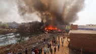 Hasiči se snaží uhasit požár v obchodě poblíž skládky během vlny veder v Novém Dillí, Indie, 27. května 2024.