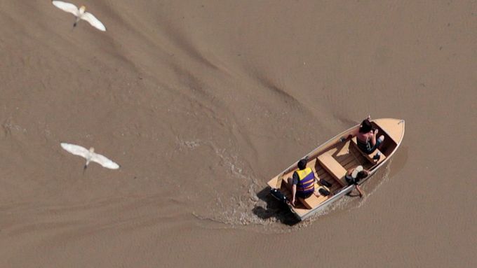 Lidé v člunu v zaplavených oblastech západně od Brisbane