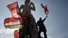 Supporters of Jean-Luc Melenchon, leader of Parti de Gauche and the Front de Gauche's candidate for the 2012 French presidential election, stand at a statue during a campaign rally in Marseille