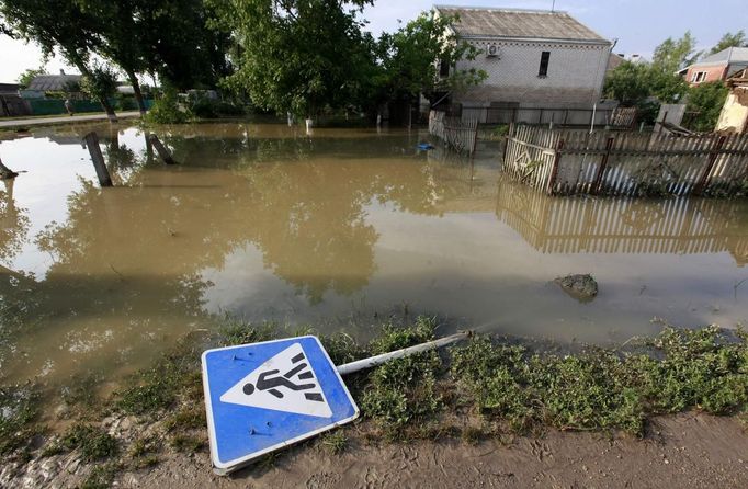 A traffic sign lays on the ground in a flooded street in the town of Krymsk in Krasnodar region, southern Russia, July 8, 2012. Russian President Vladimir Putin ordered investigators to find out if enough was done to prevent 144 people being killed in floods in southern Russia after flying to the region to deal with the first big disaster of his new presidency. REUTERS/Eduard Korniyenko (RUSSIA - Tags: DISASTER ENVIRONMENT POLITICS) Published: Čec. 8, 2012, 7:59 dop.