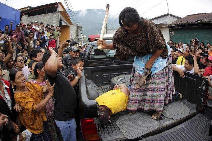 RNPS IMAGES OF THE YEAR 2012 - A woman hits a man with a stick after he is accused of theft along with three other men at Tactic, in the Alta Verapaz region, about 189 km (117 miles) from Guatemala City, September 13, 2012. The local community tied up and beat four men who were accused of theft in the aftermath of a school killing, which had occurred on Wednesday. The man, who had entered a classroom and killed two children, ages 8 and 13, with a machete, was lynched and burnt alive by a mob, local media reported. REUTERS/Jorge Dan Lopez (GUATEMALA - Tags: CRIME LAW SOCIETY) Published: Pro. 4, 2012, 1:07 dop.