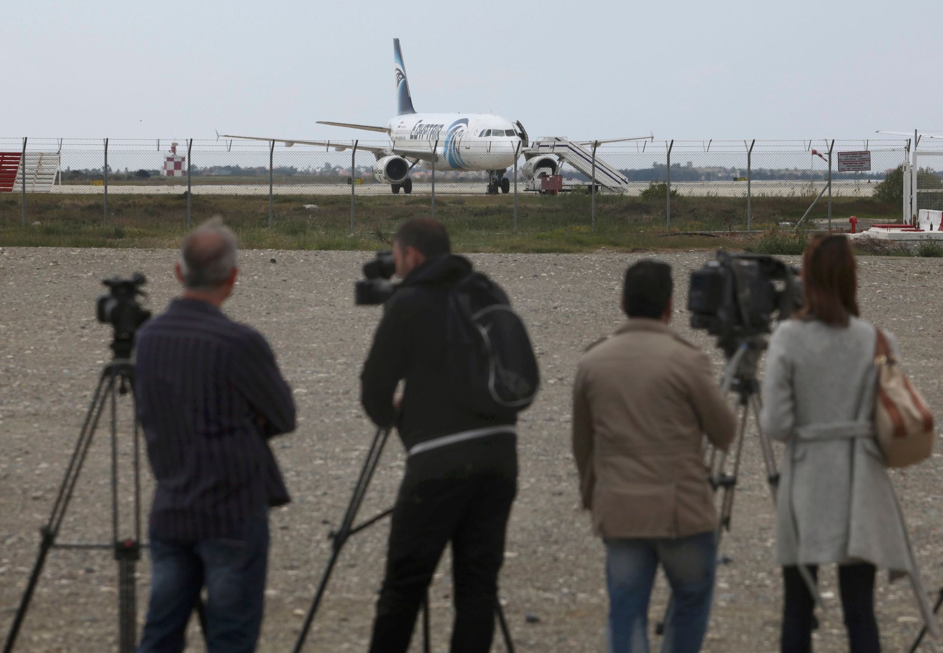 Novináři před uneseným strojem v Larnace.