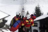Zraněného rakušana Andrease Budera doprovází dva záchranáři do vrtulníku.