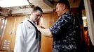 April 25, 2011 - Fort Lauderdale, Florida, U.S. - -- Fort Lauderdale, Fla. -- Phil Adams, 34, electronics technician chief, of Detroit, Michigan, helps Maxime Therrault, 22, of Massachusetts, with his dress whites as they prepare to disembark the USS Annapolis (SSN 760), a S6G nuclear reactor powered fast attack submarine, at Port Everglades in Fort Lauderdale on Monday. The USS Annapolis measures 362 ft. in length and 33 ft. at the beam, a diving depth of over 400 ft., 27+ mph, 12 vertical launch missile tubes, 4 torpedo tubes, and a crew of 130 enlisted submariners. The submarine was commissioned April 11, 1992 with its homeport in Groton, Connecticut. USS Annapolis sailed to the 21st Anniversary of Fleet Week at Port Everglades, Fort Lauderdale. (Credit Image: © Gary Coronado/The Palm Beach Post) ( automatický překlad do češtiny )