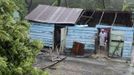 A family stand inside their home, damaged by winds from Tropical Storm Isaac, in El Habanero, Barahona province, August 25, 2012. Tropical Storm Isaac emerged over warm Caribbean waters on Saturday slightly weaker but ready to regroup after dumping torrential rains on the Dominican Republic and Haiti. REUTERS/Ricardo Rojas (DOMINICAN REPUBLIC - Tags: DISASTER ENVIRONMENT) Published: Srp. 25, 2012, 4:41 odp.