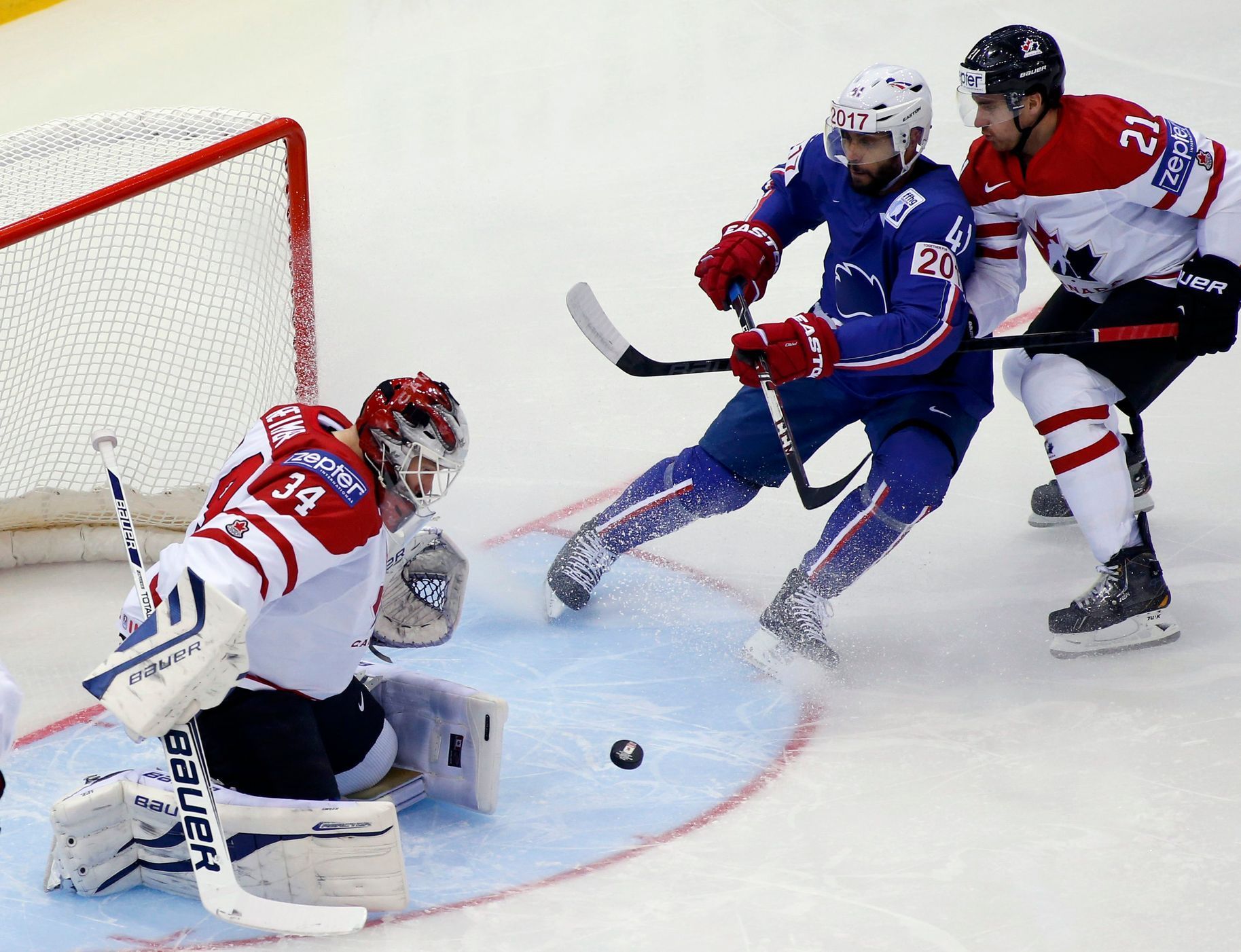 Goalkeeper Reimer and Read of Canada save in front of Bellemare of France during the first period of their men's ice hockey World Championship Group A game at Chizhovka Arena in Minsk