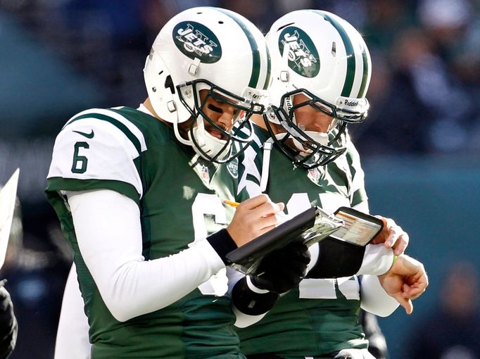 Quarterbackové New York Jets Mark Sanchez (vlevo) a Tim Tebow meditují nad zápasovými statistikami během utkání se San Diegem.