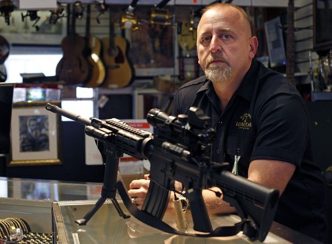 Pawn shop owner Frank James poses for a picture after deciding to discontinue the selling all firearms, including a Bushmaster AR15, pictured, at his shop Loanstar Jewelry and Pawn in Seminole, Fla., on Tuesday, Dec. 18, 2012. James says he's going to stop selling all guns and accessories in the wake of the tragedy in Connecticut. James is the father of a six-year-old girl, who is in the first grade. (AP Photo/The Tampa Bay Times, Dirk Shadd) TAMPA OUT; CITRUS COUNTY OUT; PORT CHARLOTTE OUT; BROOKSVILLE HERNANDO OUT; USA TODAY OUT; MAGS OUT