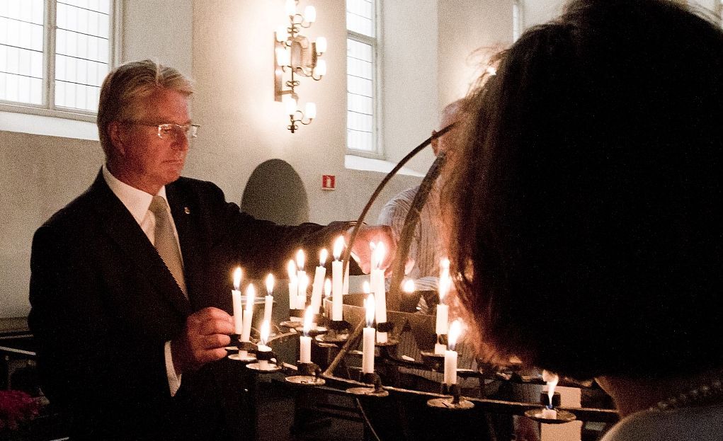 Starosta Oslo Fabian Stang zapaluje svíčku za oběti pátečního masakru