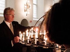 Starosta Oslo Fabian Stang zapaluje svíčku za oběti pátečního masakru