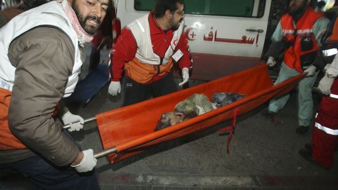 Palestinští zdravotníci přenášejí do sanitky chlapce, zraněného přoi izraelském útoku.