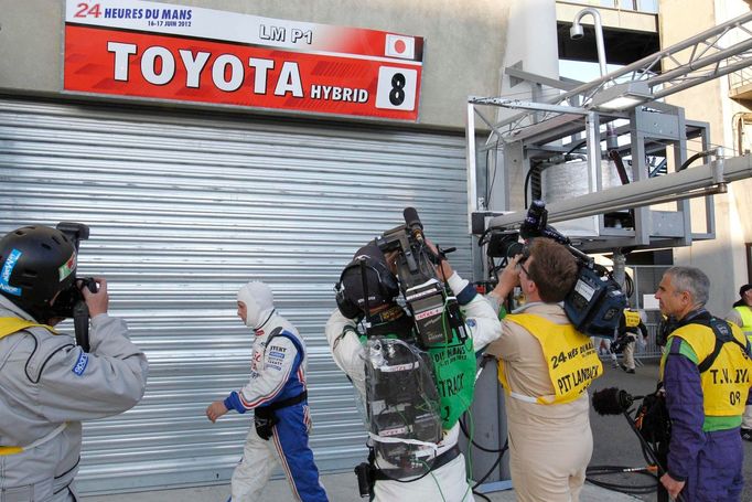 Kameramani a fotografové obléhají garáž Toyoty po nehodě Anhonyho Davidsona.