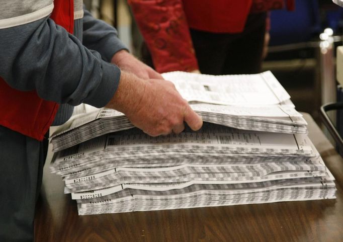 An election worker prepares to put filled-in ballots into a vote counting machine at the Denver Elections Division headquarters in downtown Denver October 25, 2012. Early voting began in swing state Colorado on Monday. REUTERS/Rick Wilking (UNITED STATES - Tags: POLITICS ELECTIONS USA PRESIDENTIAL ELECTION) Published: Říj. 26, 2012, 12:48 dop.