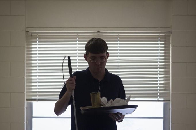 Visually impaired student Jeff Giffen holds his tray after having lunch in the cafeteria of the World Services for the Blind (WSB) in Little Rock, Arkansas January 7, 2013. The WSB is a rehabilitation center for the blind or visually impaired which offers life skills and career training programs designed to help those enrolled achieve sustainable independence. Picture taken on January 7, 2013. REUTERS/Gaia Squarci (UNITED STATES - Tags: HEALTH EDUCATION SOCIETY) Published: Dub. 26, 2013, 2:23 odp.