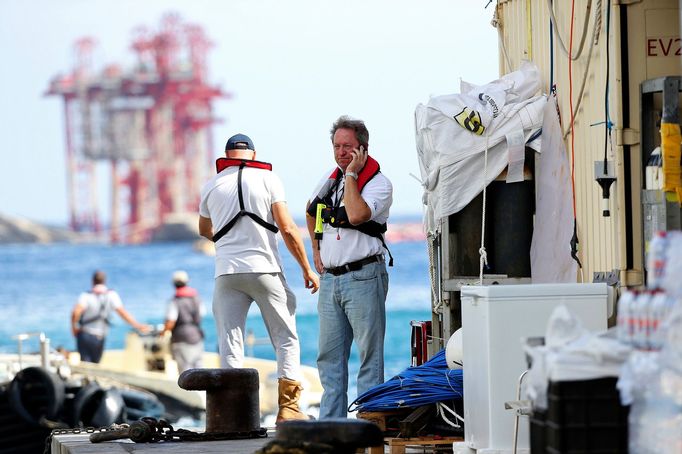 Salvage master Nick Sloane (R) talks on his mobile phone before boarding Costa Concordia cruise liner during the refloat operation at Giglio harbour at Giglio Island July