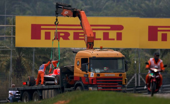 The car of Marussia Formula One driver Max Chilton of Britain is removed from the tracks during the second practice session of the Malaysian F1 Grand Prix at Sepang Inter