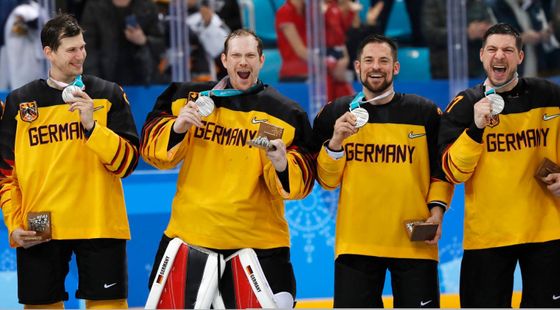 Němečtí hokejisté se stříbrnými olympijskými medailemi.
