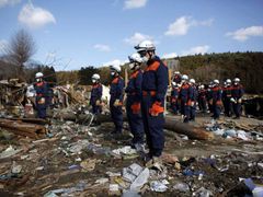 Záchranáři přerušili na minutu práci a uctívají oběti zemětřesení a tsunami.