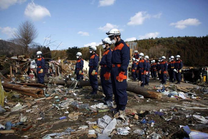 Záchranáři přerušili na minutu práci a uctívají oběti zemětřesení a tsunami.