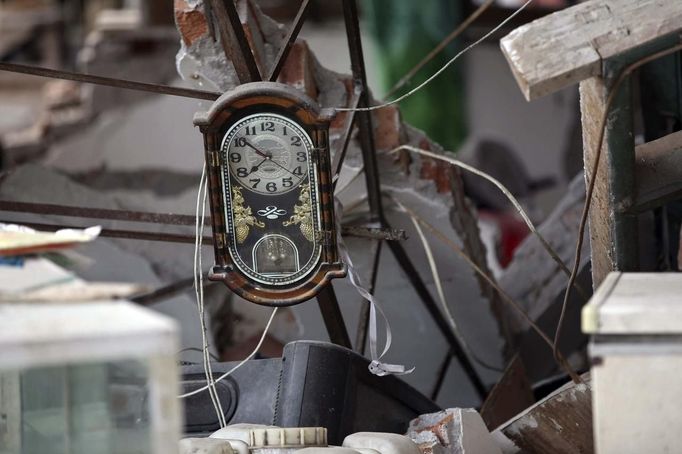 A clock is seen amidst the debris of a collapsed house after a strong 6.6 magnitude earthquake, at Longmen village, Lushan county, Ya'an, Sichuan province April 20, 2013. The earthquake hit a remote, mostly rural and mountainous area of southwestern China's Sichuan province on Saturday, killing at least 102 people and injuring about 2,200 close to where a big quake killed almost 70,000 people in 2008. REUTERS/Stringer (CHINA - Tags: DISASTER) CHINA OUT. NO COMMERCIAL OR EDITORIAL SALES IN CHINA Published: Dub. 20, 2013, 9:38 dop.