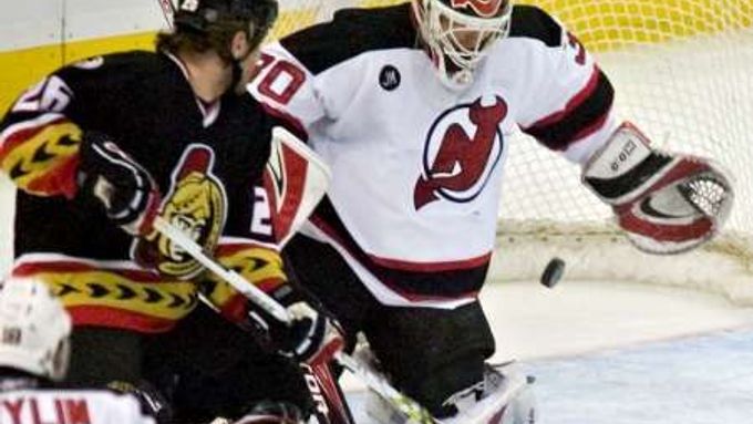 Brankář New Jersey Devils Martin Brodeur sleduje puk z hole útočníka Ottawy Senators Václava Varadi.