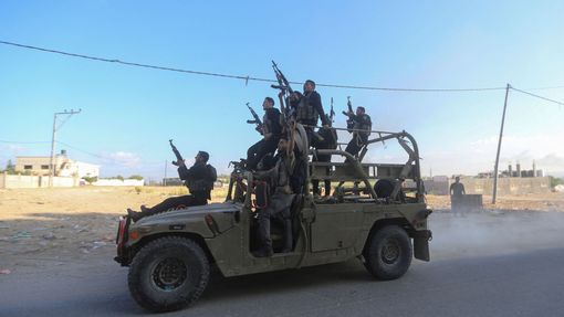 Palestinští ozbrojenci na izraelském vojenském automobilu.