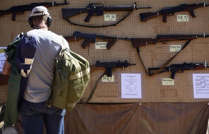 A man look at different rental guns displayed during the Big Sandy Shoot in Mohave County, Arizona March 22, 2013. The Big Sandy Shoot is the largest organized machine gun shoot in the United States attended by shooters from around the country. Vintage and replica style machine guns and cannons are some of the weapons displayed during the event. Picture taken March 22, 2013. REUTERS/Joshua Lott (UNITED STATES - Tags: SOCIETY) Published: Bře. 25, 2013, 3:35 odp.