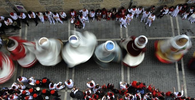 Performers dressed as oversized traditional figures dance through the streets during the San Fermin festival in Pamplona July 10, 2012. Visitors to the nine-day festival, depicted in Ernest Hemingway's 1926 novel "The Sun Also Rises", take part in activities including the running of the bulls, an early morning half-mile dash from the corral to the bullring alongside six bulls destined to die in the afternoon's corrida. This is followed by processions of giant traditional figures, concerts, firebulls, fireworks, and large doses of eating, drinking, dancing and late nights. REUTERS/Eloy Alonso (SPAIN - Tags: SOCIETY TPX IMAGES OF THE DAY) Published: Čec. 10, 2012, 9:50 dop.