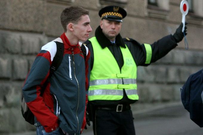 Před střední školou v polském Ciezsyně řídí policista dopravu, aby se studenti bezpečně dostali do třídy.