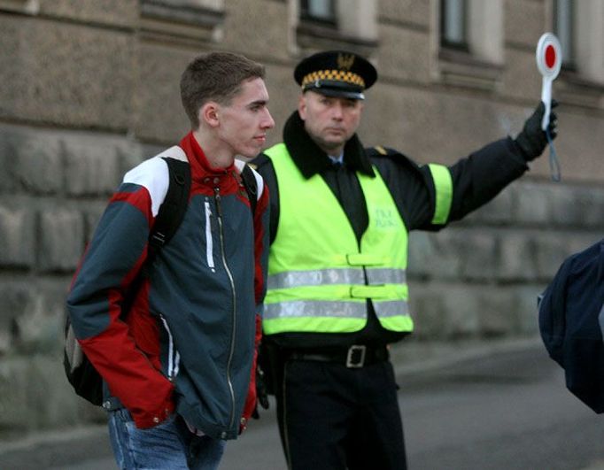 Před střední školou v polském Ciezsyně řídí policista dopravu, aby se studenti bezpečně dostali do třídy.