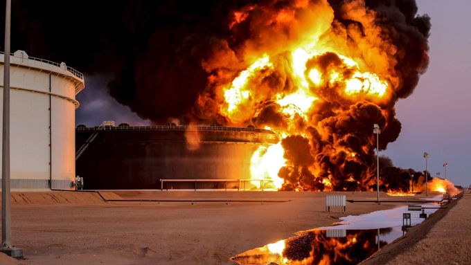 Hořící zásobník ropy po útoku Islámského státu na rafinérii v Rás Lanúfu.