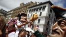 A boy wearing a "Kiliki" mask tries to hit a "Kiliki" with a sponge during San Fermin festival's "Comparsa de gigantes y cabezudos" (Parade of the giants and the big heads) in Pamplona July 11, 2012. "Kilikis", wearing oversized masks as they playfully hit bystanders with sponges on sticks, parade daily through the city accompanied by brass bands during the nine-day-long festival made popular by U.S. writer Ernest Hemingway. REUTERS/Susana Vera (SPAIN - Tags: SOCIETY) Published: Čec. 11, 2012, 2:09 odp.