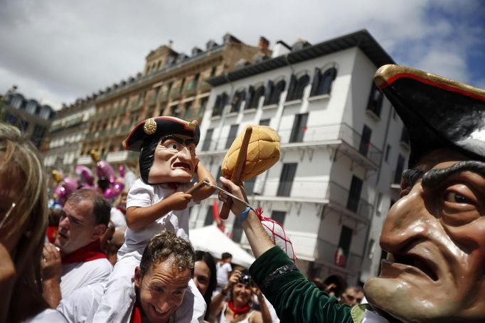 A boy wearing a "Kiliki" mask tries to hit a "Kiliki" with a sponge during San Fermin festival's "Comparsa de gigantes y cabezudos" (Parade of the giants and the big heads) in Pamplona July 11, 2012. "Kilikis", wearing oversized masks as they playfully hit bystanders with sponges on sticks, parade daily through the city accompanied by brass bands during the nine-day-long festival made popular by U.S. writer Ernest Hemingway. REUTERS/Susana Vera (SPAIN - Tags: SOCIETY) Published: Čec. 11, 2012, 2:09 odp.