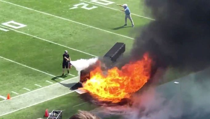 People try and extinguish fire from burning equipment used during pregame, during the Tennessee Titans' NFL match against the Indianapolis Colts, in Nashville, Tennessee,