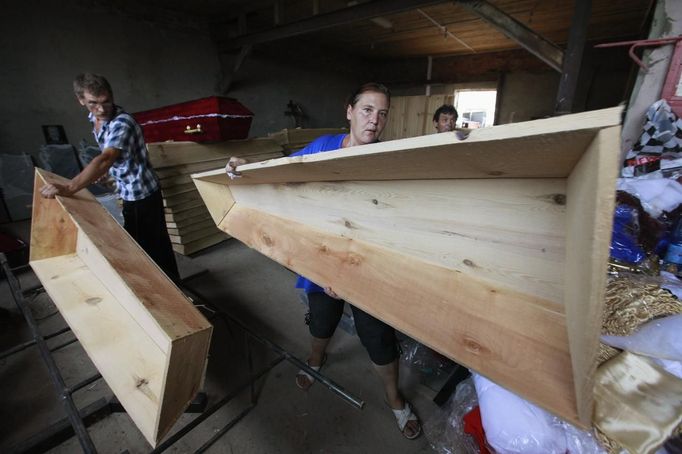 Employees of a workshop produce coffins for flood victims at a city cemetery in the town of Krymsk in Krasnodar region, southern Russia, July 8, 2012. Russian President Vladimir Putin ordered investigators to find out if enough was done to prevent 144 people being killed in floods in southern Russia after flying to the region to deal with the first big disaster of his new presidency. REUTERS/Eduard Korniyenko (RUSSIA - Tags: DISASTER ENVIRONMENT POLITICS) Published: Čec. 8, 2012, 4:28 odp.